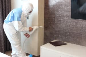 featured image showing a technician sanitizing a room using steam and ozone, after the COVID-19 pandemic